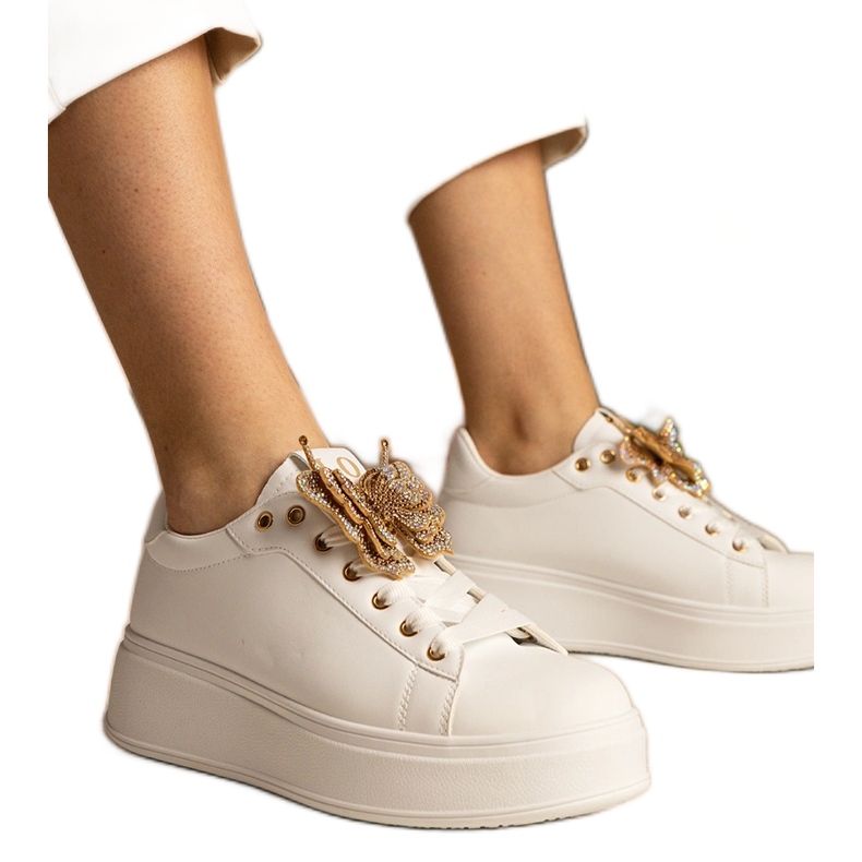 Zapatillas blancas decoradas con una mariposa con circones blanco