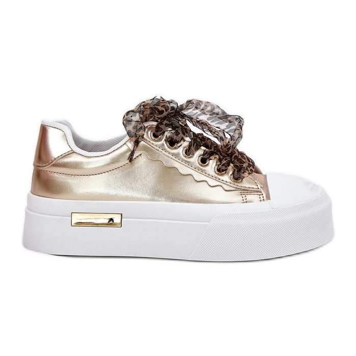 Zapatillas de deporte para mujeres en una plataforma masiva con oro decorativo dorado