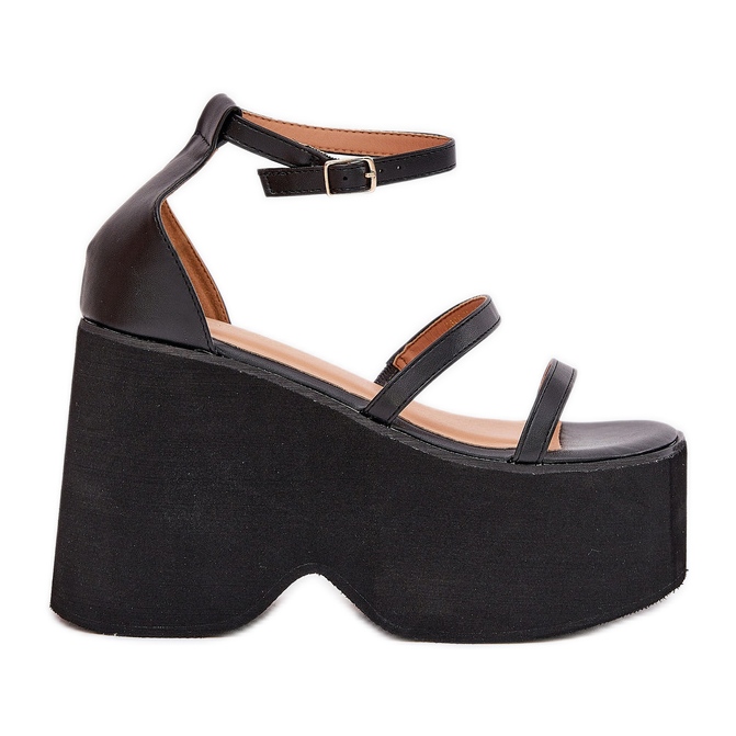 Sandalias de mujeres en una plataforma masiva y cuñas negras negro