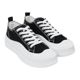 Zapatillas blancas y negras con suela gruesa. negro