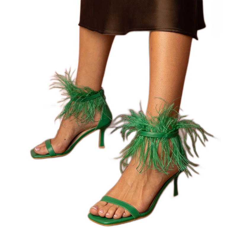 Sandalias verdes en un alfiler con plumas Sandalias verdes en un alfiler con plumas