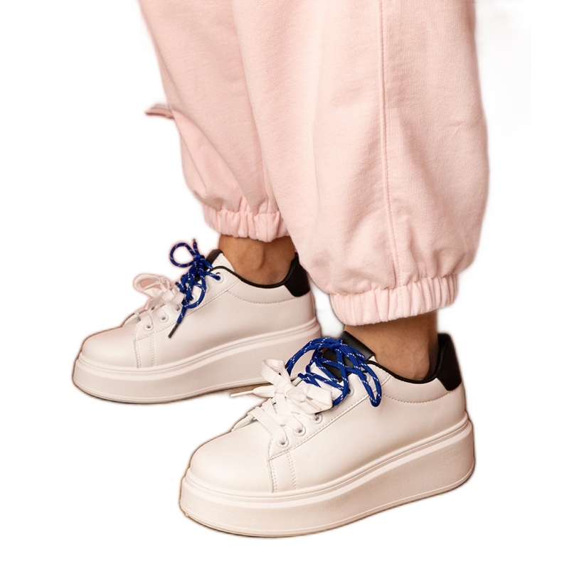 Zapatillas deportivas blancas en la plataforma blanco