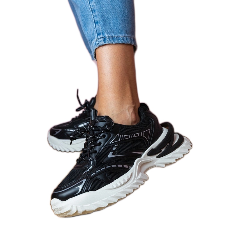 Zapatillas deportivas negras en una suela gruesa negro