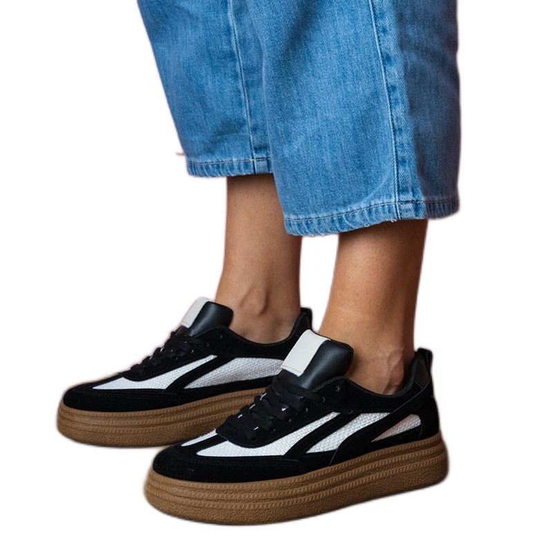 Zapatillas de deporte negras en una suela gruesa negro