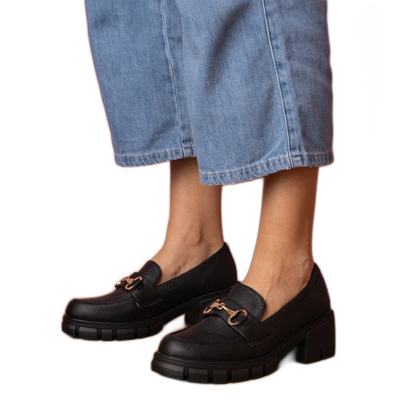 Zapatos negros en un poste bajo con una decoración dorada