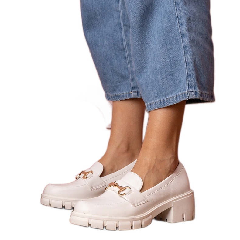 Zapatos blancos en un poste bajo con un adorno dorado
