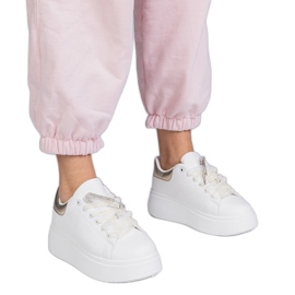 Zapatillas blancas con un inserto dorado y un alfiler de circón blanco