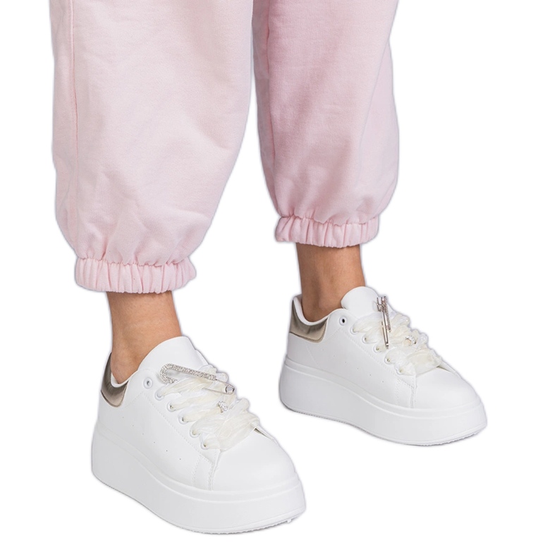 Zapatillas blancas con un inserto dorado y un alfiler de circón blanco