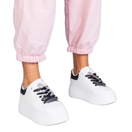 Zapatillas blancas con un inserto negro y un alfiler de circón blanco