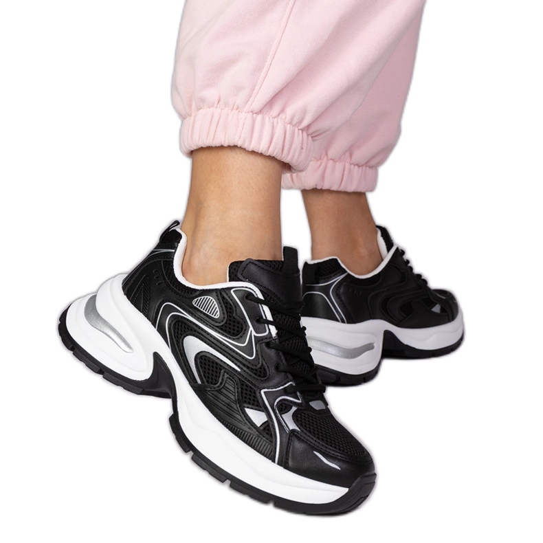 Zapatillas deportivas negras en una suela gruesa negro Zapatillas deportivas negras en una suela gruesa negro