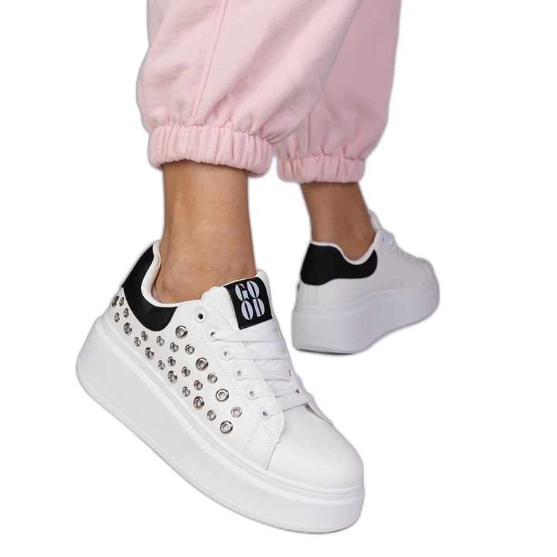 Zapatillas blancas con un inserto negro y tachuelas blanco