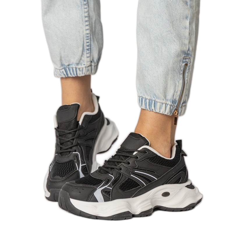 Zapatillas de deporte de deportes negros en una suela masiva