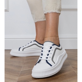 Zapatillas blancas de mujer en la plataforma. blanco