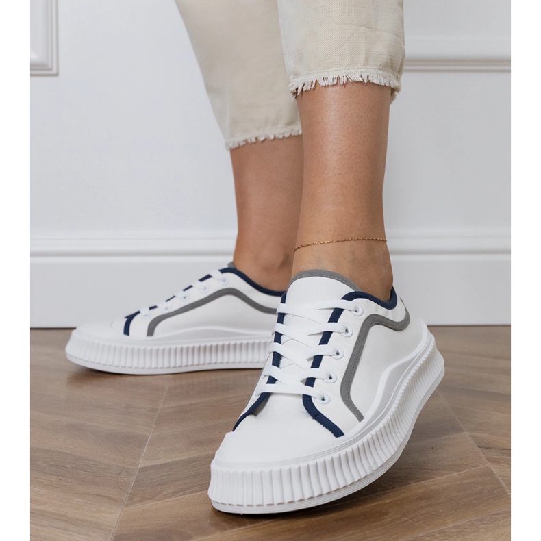 Zapatillas blancas de mujer en la plataforma. blanco