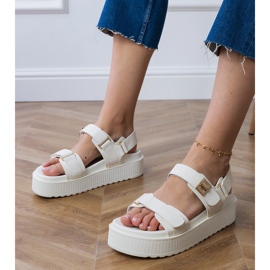 Sandalias blancas en la plataforma con correas en el velcro blanco Sandalias blancas en la plataforma con correas en el velcro blanco