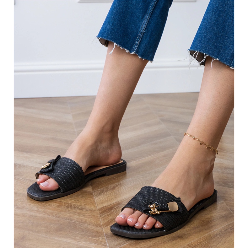 Chanclas negras planas con una decoración dorada negro