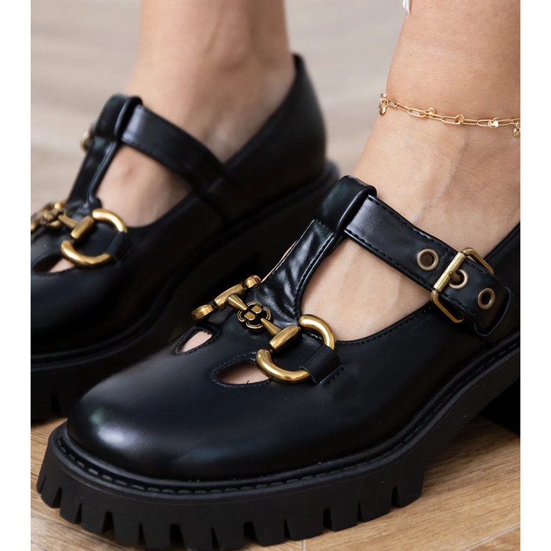Zapatos negros en una suela gruesa con una decoración dorada