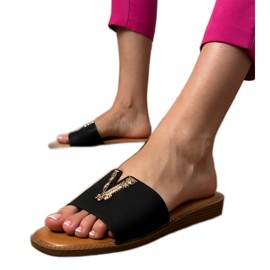 Chanclas negras con una decoración dorada negro