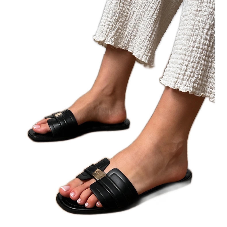 Zapatillas de mujer negra con un adorno en el cinturón negro