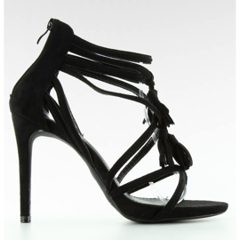 Sandalias en un pin con borlas negras. negro
