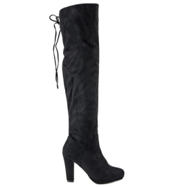 Botas de muslo de ante en el poste negro