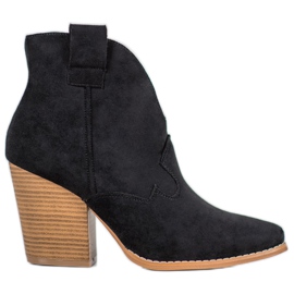 Botas de vaquero de gamuza en el pilar negro