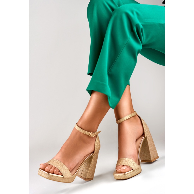 Sandalias doradas brillantes en un tacón alto ancho dorado 1