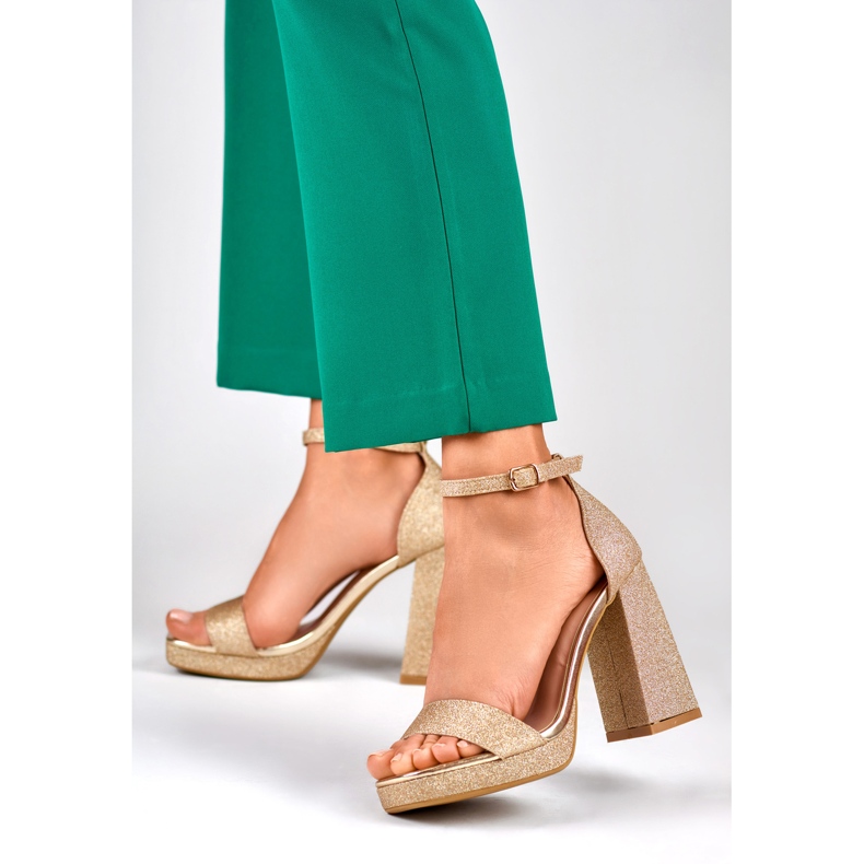 Sandalias doradas brillantes en un tacón alto ancho dorado 2