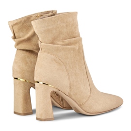 Botas beige de mujer en un puesto decorado 1 Botas beige de mujer en un puesto decorado 1