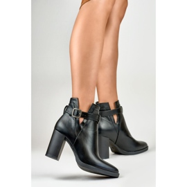 Botas negras recortadas para mujer en un poste beige 3