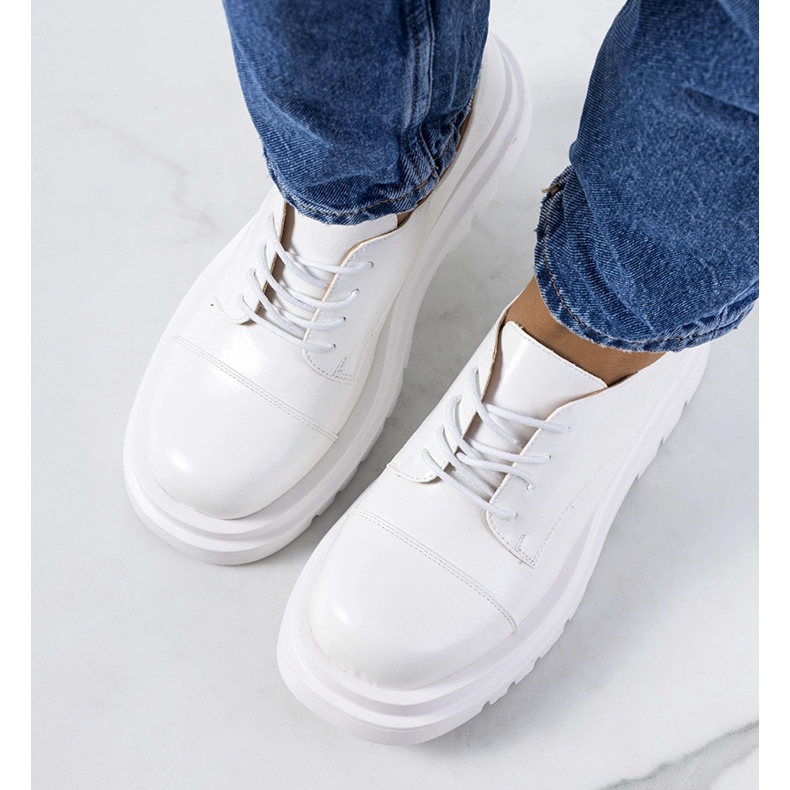 Zapatos blancos en una suela de tractor de Henta 1