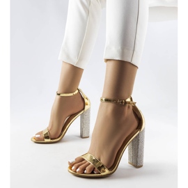 Sandalias doradas en un poste decorativo de Rette dorado 1