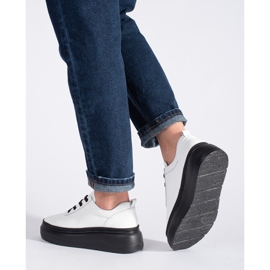 Zapatos blancos de cuero sobre una plataforma negra. 3
