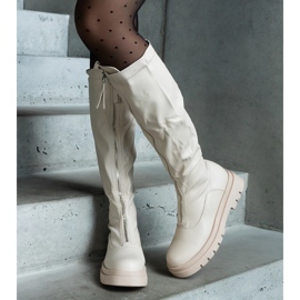 Botas de ecopiel beige con tacón plano decorado con cremallera. 2