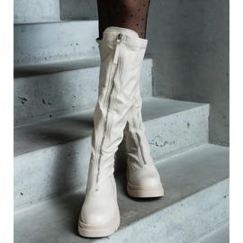 Botas de ecopiel beige con tacón plano decorado con cremallera. 1