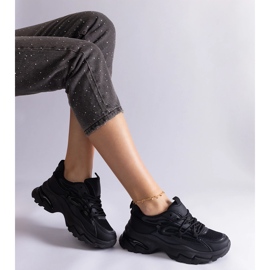 Zapatillas de deporte de deportes negros en una suela masiva 2