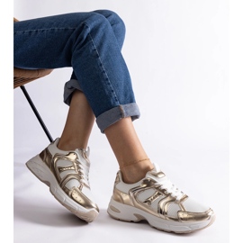 Zapatillas deportivas blancas y doradas. dorado 1