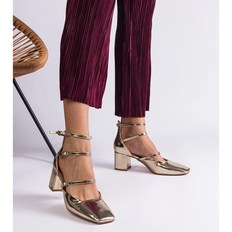 Bombas doradas barnizadas en un pilar con hebillas dorado 1