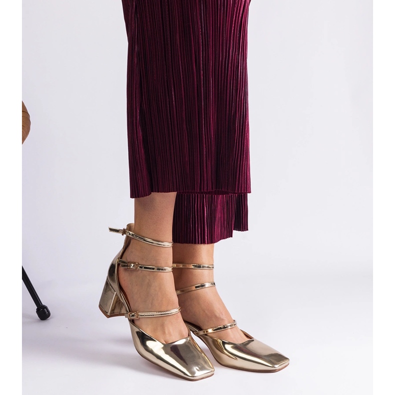 Bombas doradas barnizadas en un pilar con hebillas dorado 2