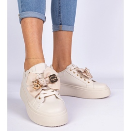 Zapatillas beige decoradas con un arco y un oso de peluche dorado 2
