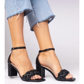 Sandalias negras en el poste cubierto negro 1
