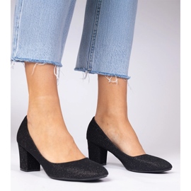 Bombas de mujeres negras con un acabado material negro 3