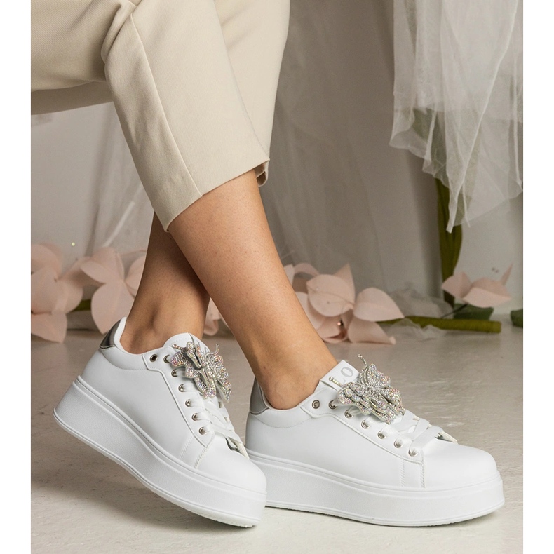 Zapatillas blancas y plateadas decoradas con una mariposa con circones blanco 1