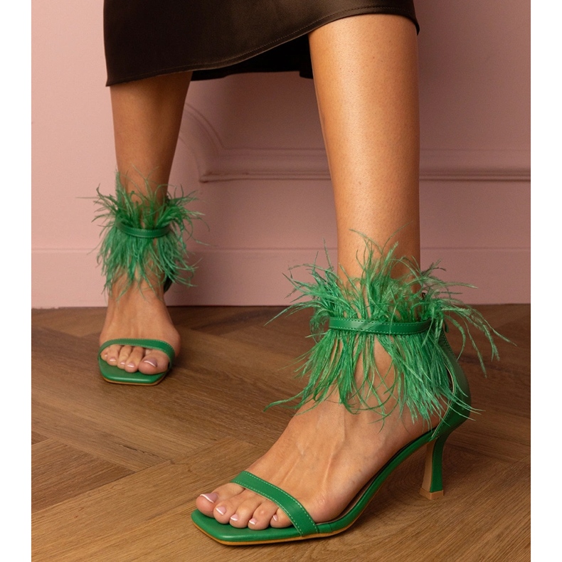 Sandalias verdes en un alfiler con plumas 1
