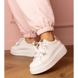 Zapatillas de deporte de deportes blancos y dorados en la plataforma 2