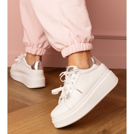Zapatillas deportivas blancas y plateadas en la plataforma blanco 3
