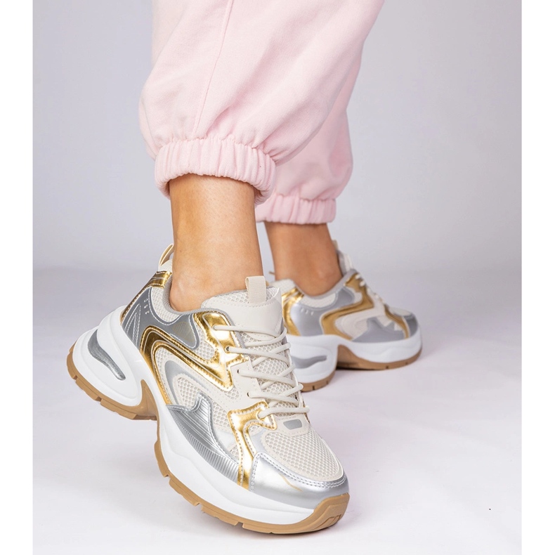 Zapatillas de deporte de deportes dorados en una suela gruesa 1 Zapatillas de deporte de deportes dorados en una suela gruesa 1