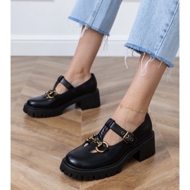 Zapatos negros en una suela gruesa con una decoración dorada 1