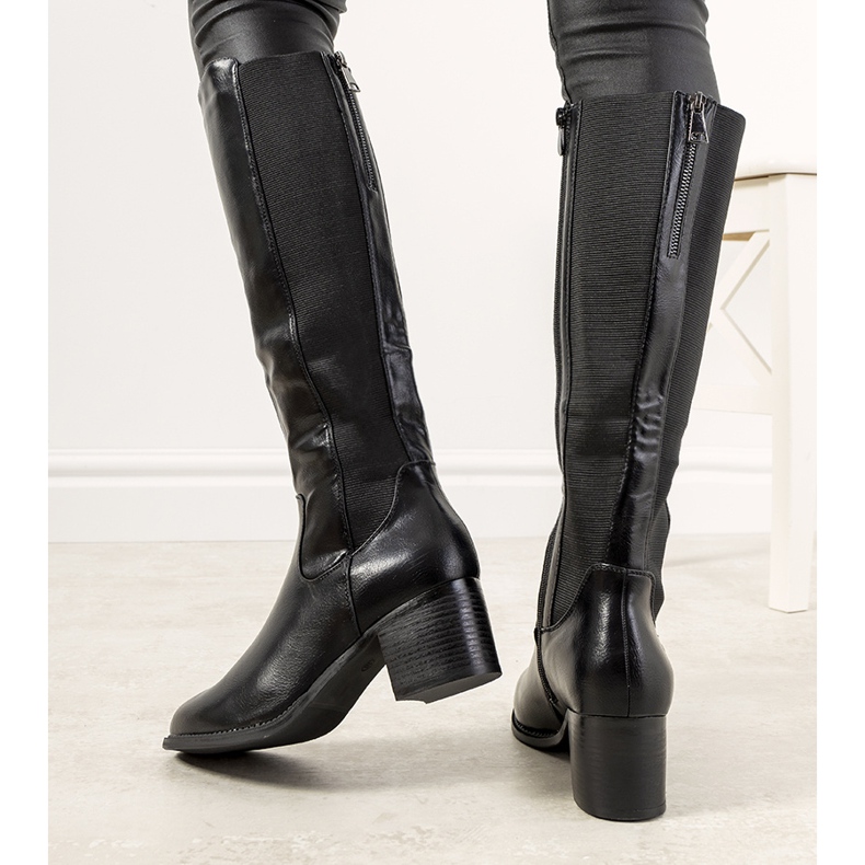 Botas negras en el poste Jurado aislado negro 1 Botas negras en el poste Jurado aislado negro 1