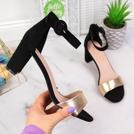Sandalias de mujer negras y doradas en el puesto eVento. 1